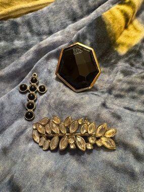 Black cross pendant with crystal like brooch and black fashionable ring.